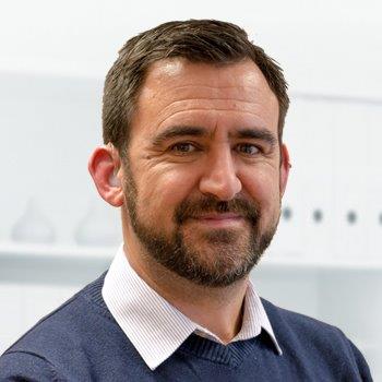 Owner of WP Ability with a beard smiling in an office